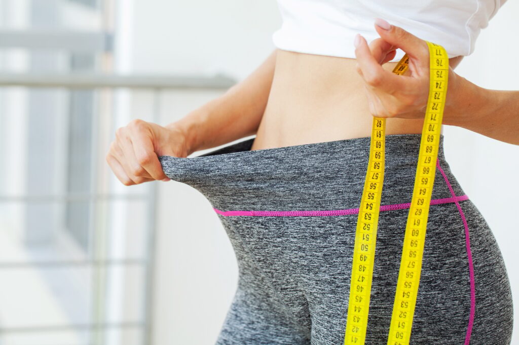 Woman in oversize pants after weight loss, diet concept.