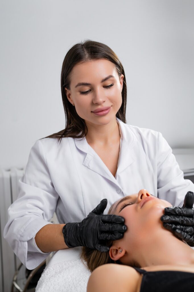 Young cosmetologist woman doing hydra facial treatment for young woman in beauty salon